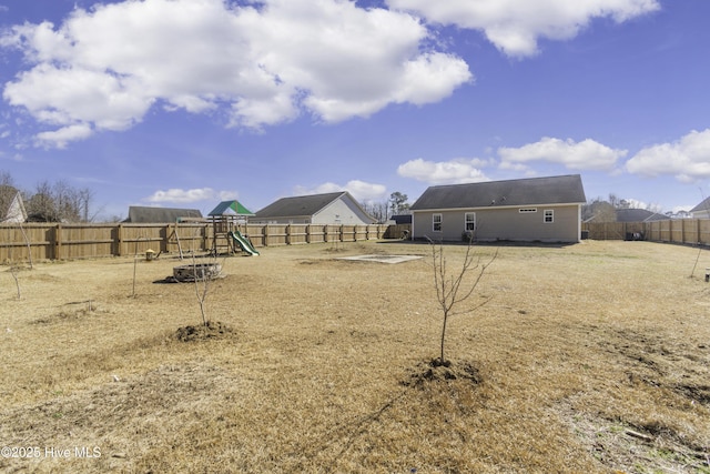 view of yard with a fenced backyard and a playground