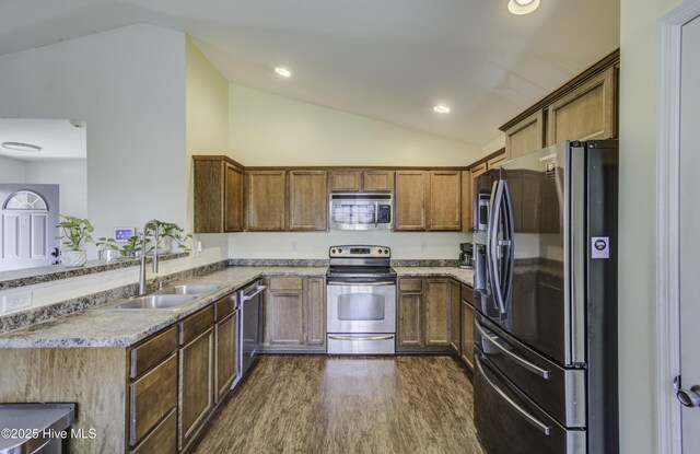 kitchen with stainless steel appliances, lofted ceiling, sink, and dark hardwood / wood-style flooring