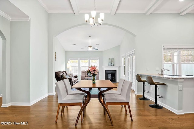 dining area with beamed ceiling, dark hardwood / wood-style floors, and ceiling fan with notable chandelier