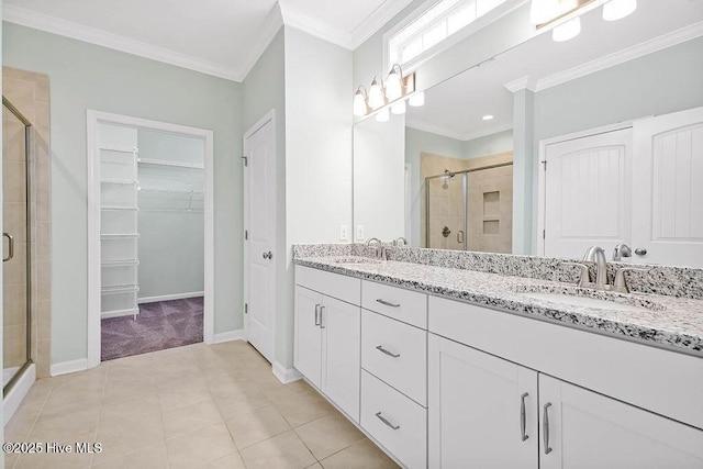 bathroom featuring an enclosed shower, vanity, crown molding, and tile patterned floors