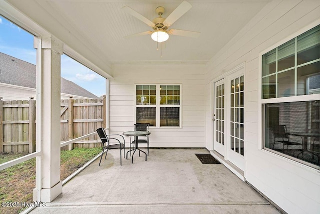 unfurnished sunroom with ceiling fan