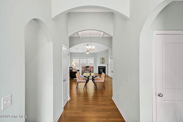 hallway with hardwood / wood-style flooring and a chandelier