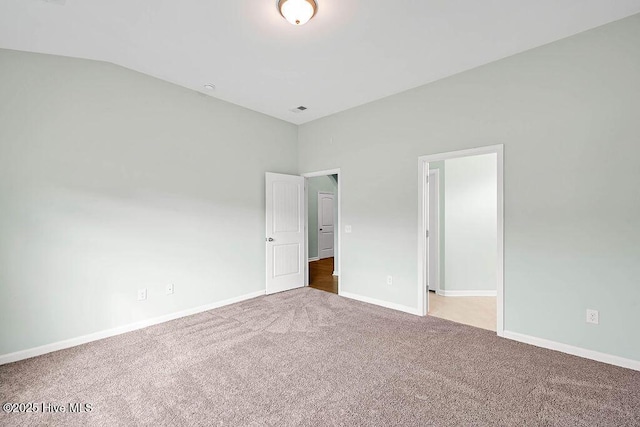 unfurnished bedroom with vaulted ceiling and carpet