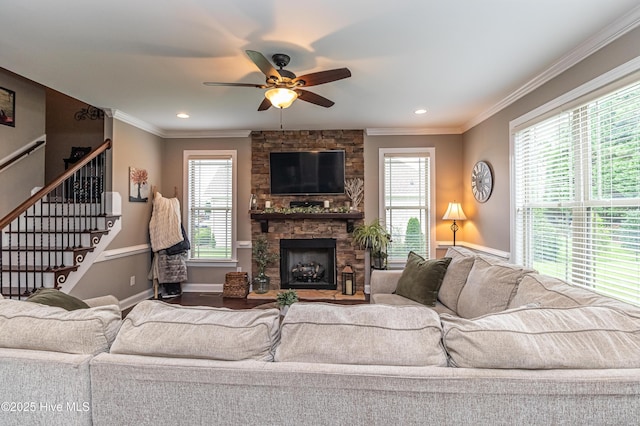 living room with crown molding, plenty of natural light, and a fireplace