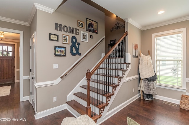 stairway featuring crown molding, a healthy amount of sunlight, and hardwood / wood-style floors