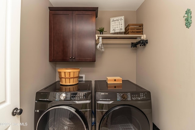 clothes washing area featuring cabinets and independent washer and dryer