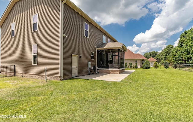 back of house with a sunroom, a patio area, and a lawn