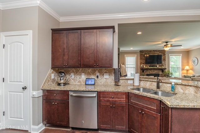 kitchen featuring light stone counters, stainless steel dishwasher, sink, and a wealth of natural light