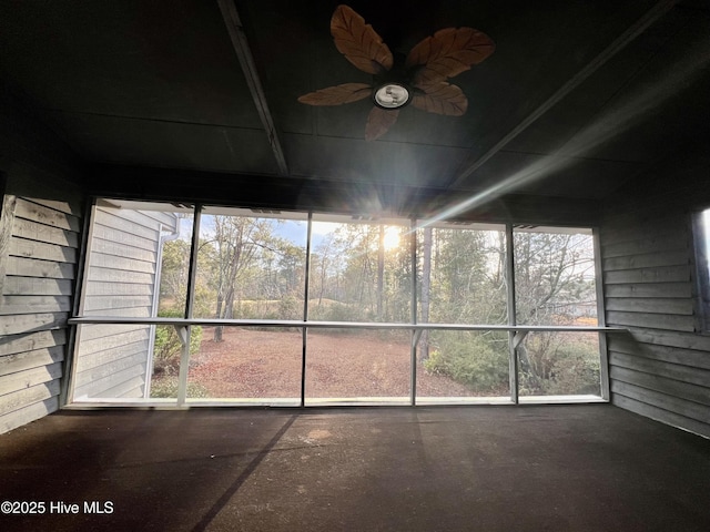 unfurnished sunroom featuring ceiling fan