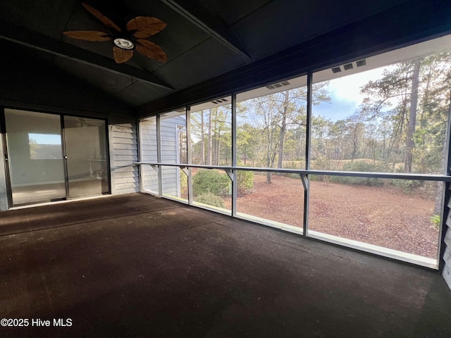 unfurnished sunroom with ceiling fan, plenty of natural light, and vaulted ceiling