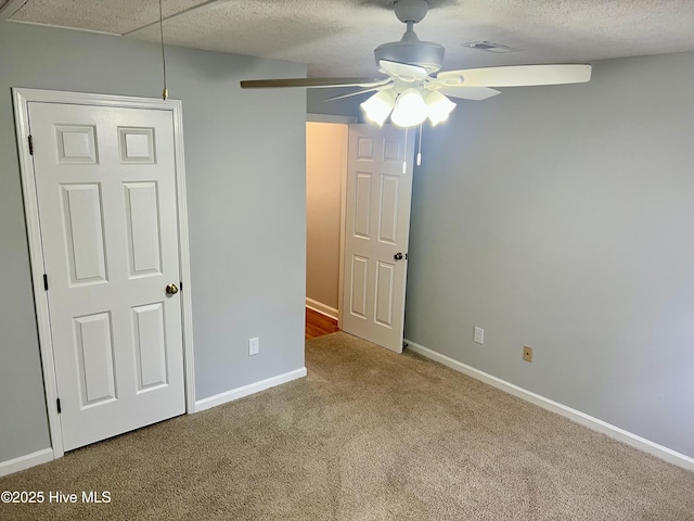 unfurnished bedroom with ceiling fan, carpet floors, and a textured ceiling