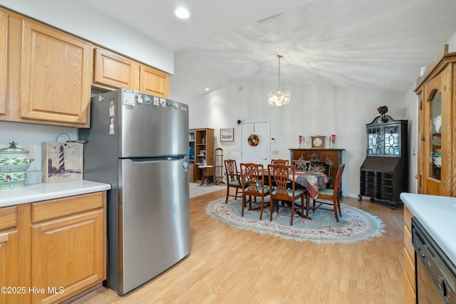 kitchen with pendant lighting, vaulted ceiling, stainless steel refrigerator, and light hardwood / wood-style flooring