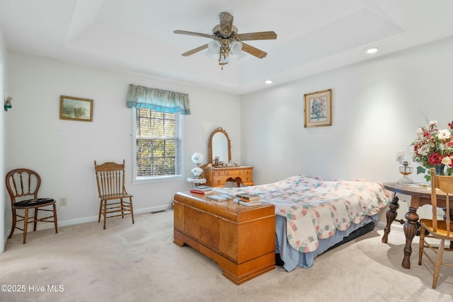 bedroom with a tray ceiling and light colored carpet