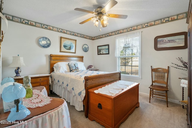 carpeted bedroom with ceiling fan and a textured ceiling