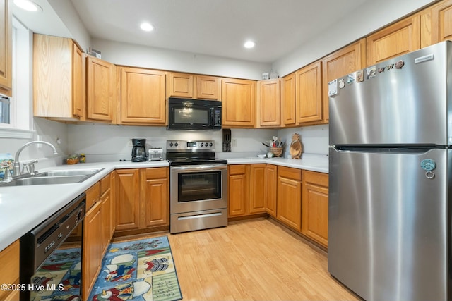 kitchen featuring sink, light hardwood / wood-style flooring, and black appliances