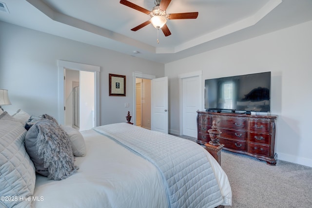 bedroom featuring a raised ceiling, carpet flooring, and ceiling fan