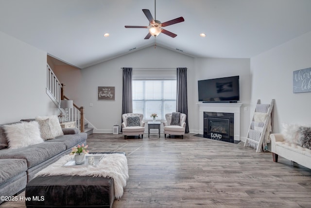 living room with hardwood / wood-style flooring, lofted ceiling, and ceiling fan