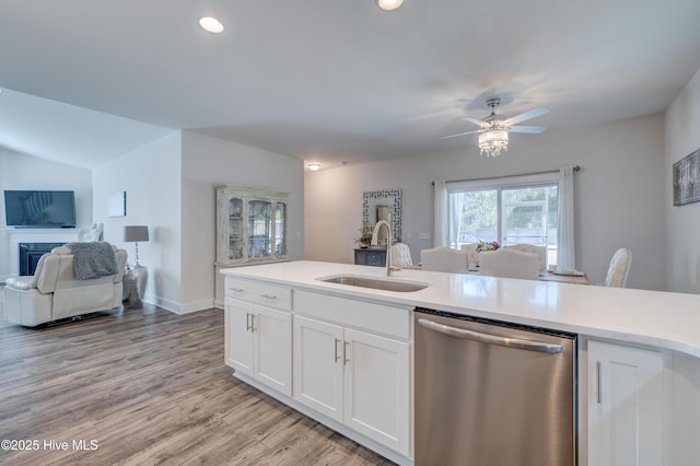 kitchen featuring sink, ceiling fan, white cabinetry, light hardwood / wood-style floors, and stainless steel dishwasher