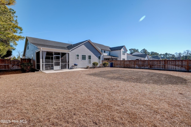 back of property with a sunroom and a patio