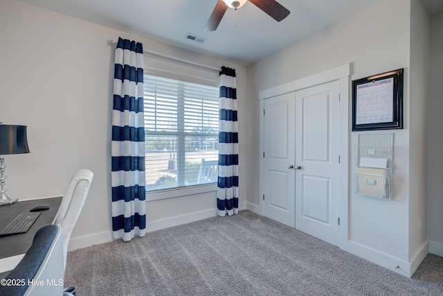 carpeted home office featuring ceiling fan