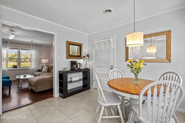 dining space with light tile patterned flooring and ornamental molding