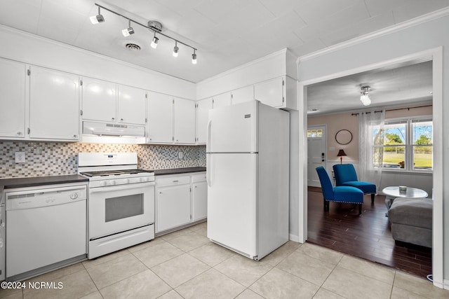 kitchen featuring white cabinetry, crown molding, tasteful backsplash, light tile patterned floors, and white appliances