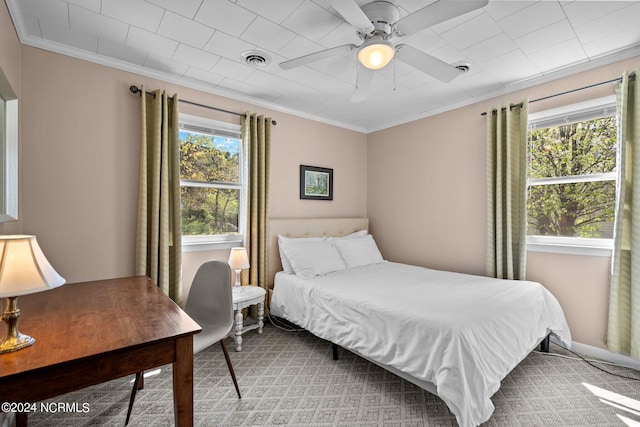 carpeted bedroom featuring ceiling fan, ornamental molding, and multiple windows