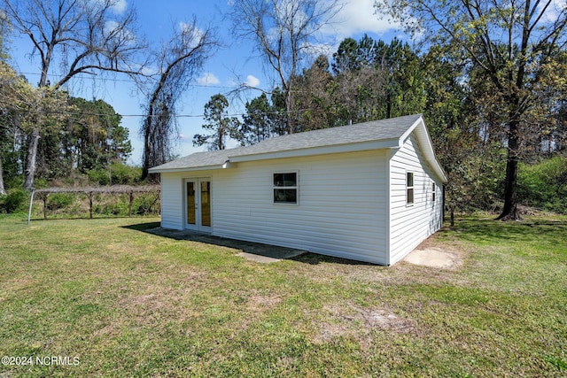 rear view of property featuring a yard and french doors