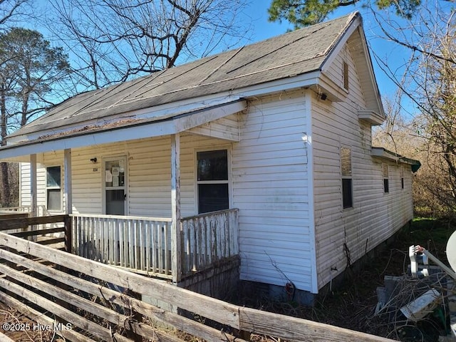 bungalow-style house with a shingled roof and a porch