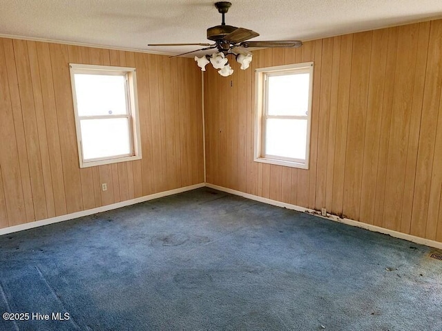 unfurnished room with a wealth of natural light, dark carpet, and a textured ceiling