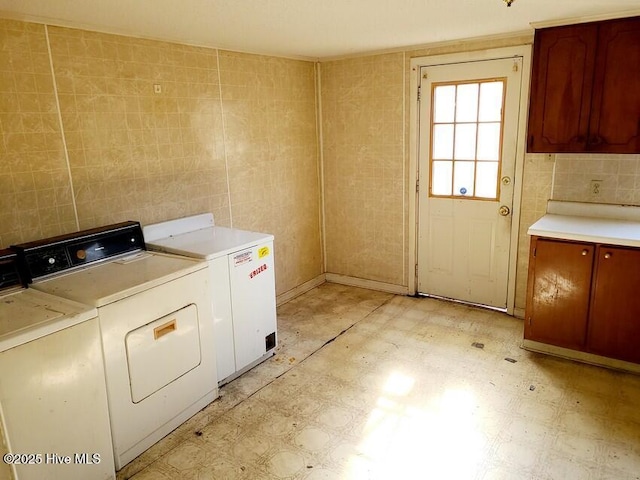 laundry area featuring light floors, cabinet space, and independent washer and dryer