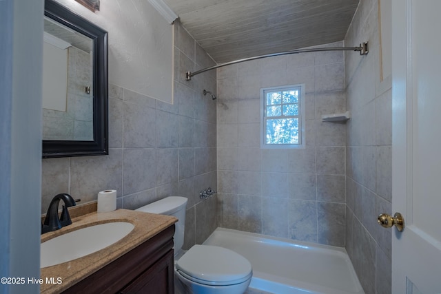 bathroom with vanity, tile walls, toilet, and a tile shower