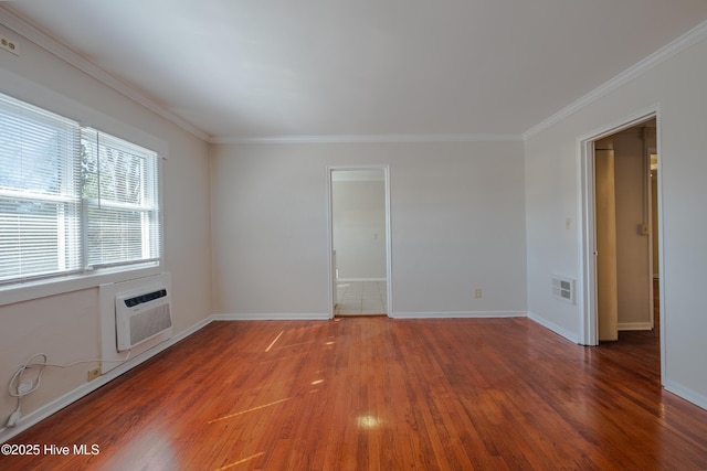 spare room featuring crown molding, a wall mounted air conditioner, and hardwood / wood-style floors