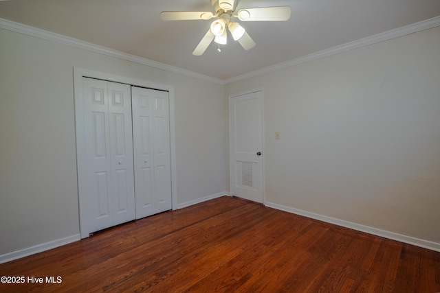 unfurnished bedroom with dark hardwood / wood-style flooring, ornamental molding, and a closet