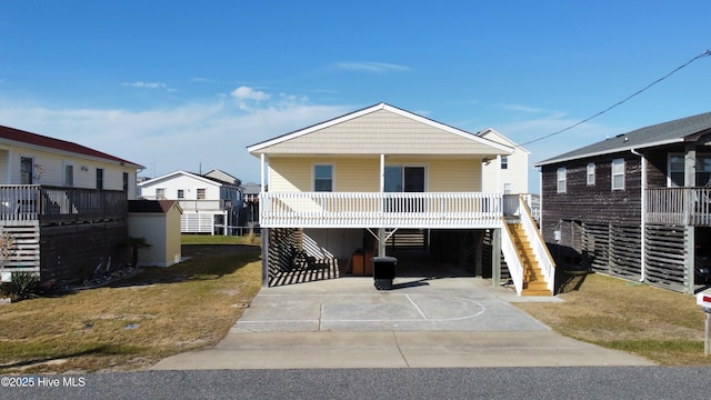 raised beach house featuring a carport and a porch