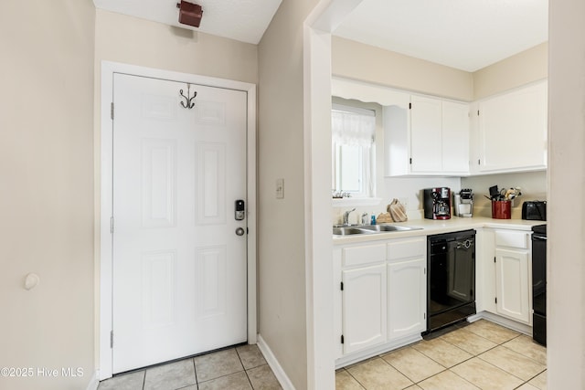 kitchen featuring sink, white cabinetry, light tile patterned floors, dishwasher, and range with electric cooktop