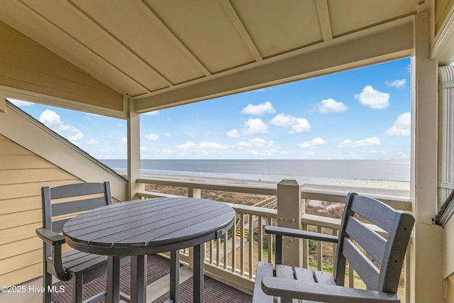 balcony featuring a water view and a beach view