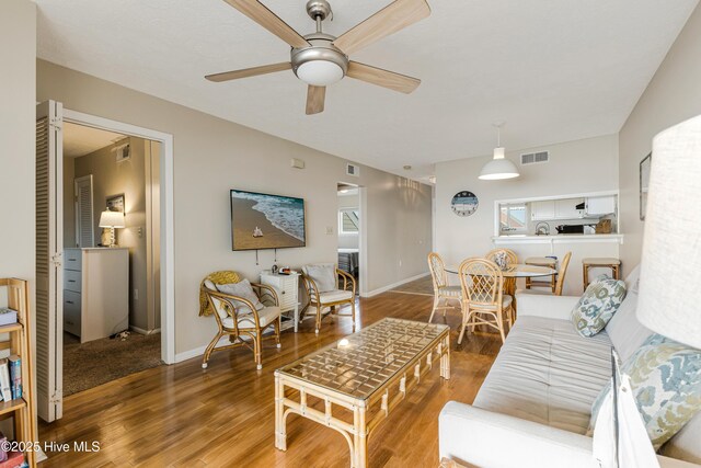 living room featuring hardwood / wood-style floors and ceiling fan