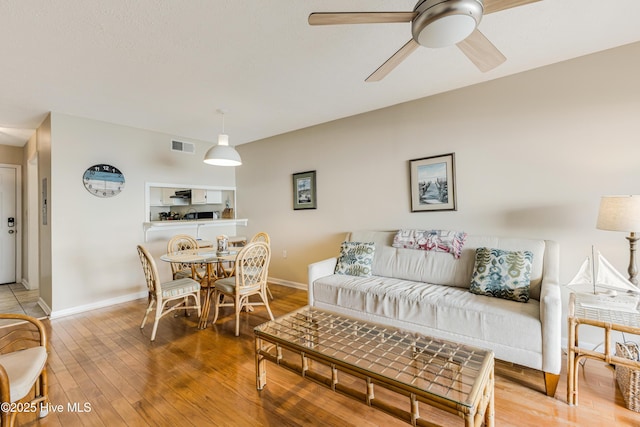 living room featuring hardwood / wood-style floors and ceiling fan