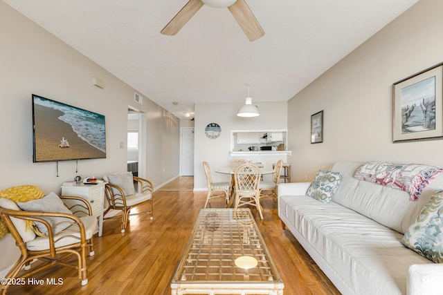 living room featuring ceiling fan and light hardwood / wood-style flooring