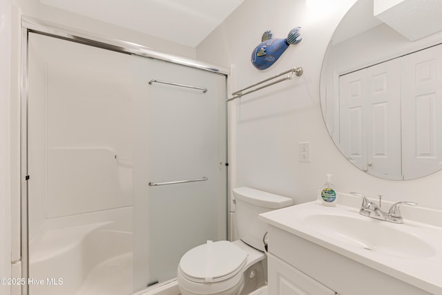 bathroom featuring toilet, vanity, and walk in shower