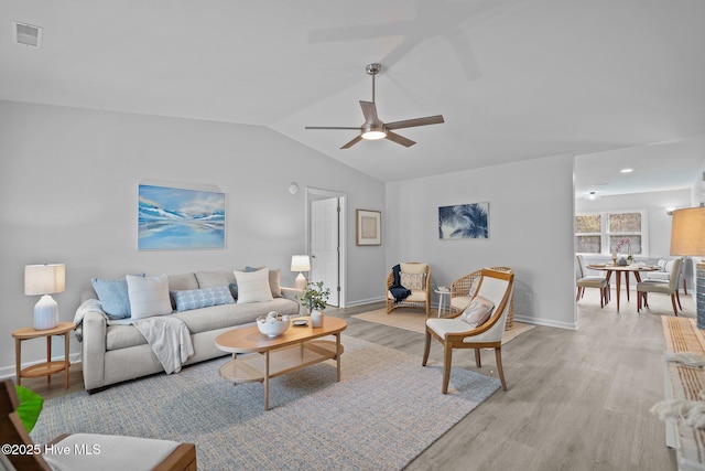 living room with vaulted ceiling, ceiling fan, and light wood-type flooring