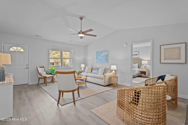 living room featuring ceiling fan, vaulted ceiling, and light hardwood / wood-style flooring