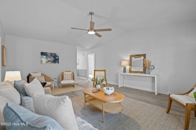 living room featuring ceiling fan, wood-type flooring, and vaulted ceiling