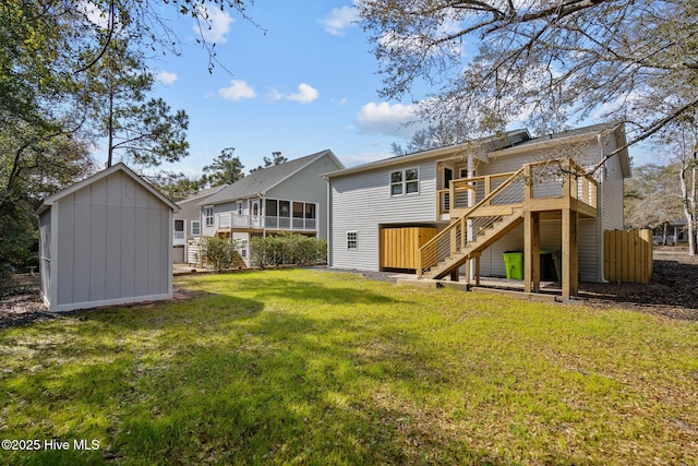 back of house with a wooden deck, a lawn, and a storage shed