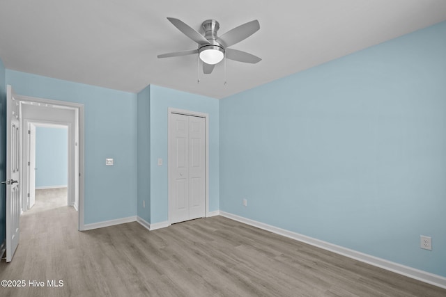 unfurnished bedroom featuring light hardwood / wood-style flooring, a closet, and ceiling fan