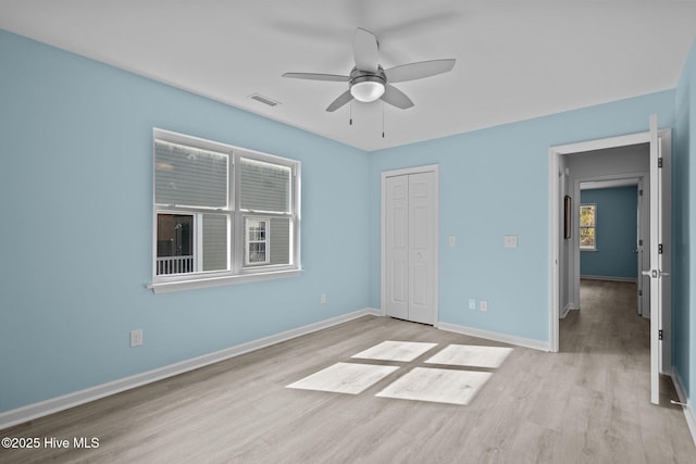 unfurnished bedroom featuring light hardwood / wood-style floors, a closet, and ceiling fan