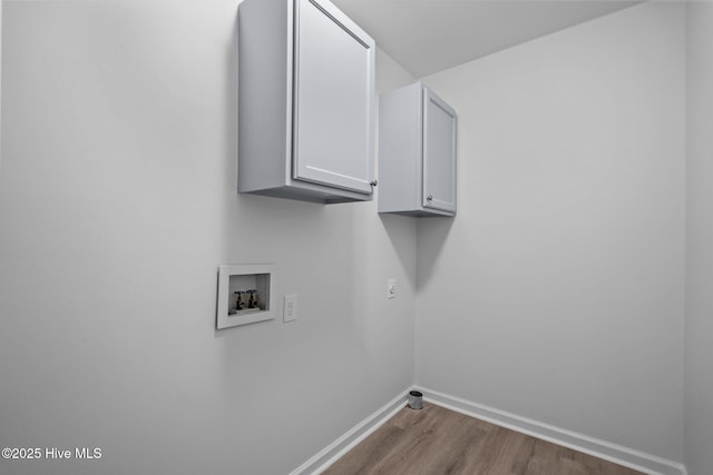 washroom with cabinets, wood-type flooring, and washer hookup