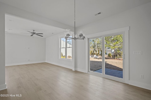 unfurnished dining area with hardwood / wood-style flooring and ceiling fan with notable chandelier