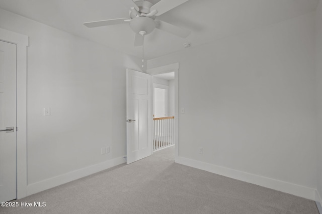 empty room featuring light colored carpet and ceiling fan